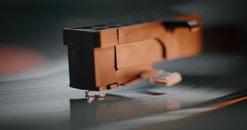 Macro Close Up of Needle Gently Scratching Grooves Playing Music on Vinyl Record Player