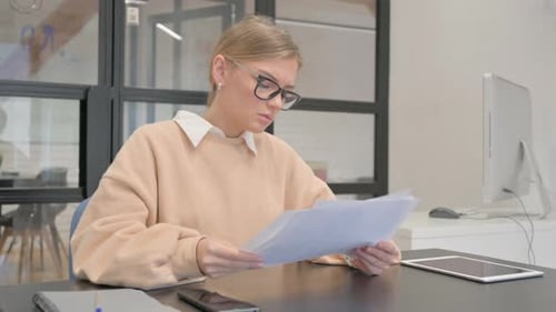 Female Worker Reading Documents at Work