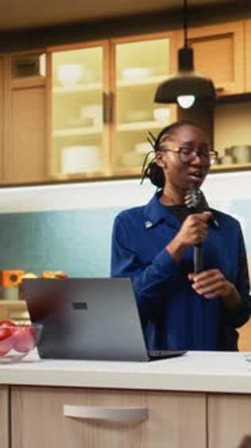 Enthusiastic Woman Singing with Spatula in Kitchen