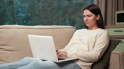 Woman Working on Laptop Computer at Home
