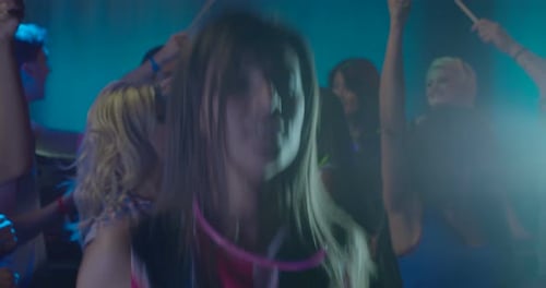 Frau tanzt mit Freunden und hat Spaß im Nachtclub