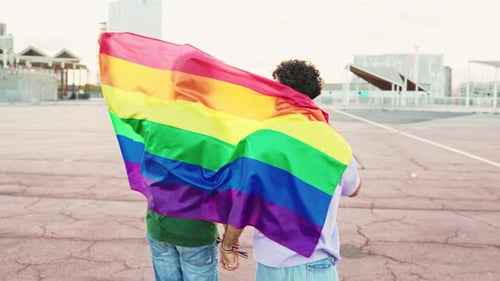 Gay Couple Holding Pride Flag in City