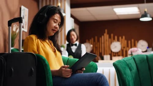 Asian Tourist Working on Tablet in Lounge Area at Resort