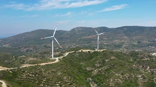 Wind Turbines on Rolling Hills Under Blue Sky