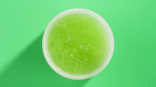 Aguacates frescos maduros con crema y aceite esencial sobre fondo verde con maquillaje de menta y mentol
