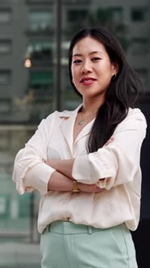 Young Asian Business Woman Crossing Arms Outside Office Building in the Corporate City