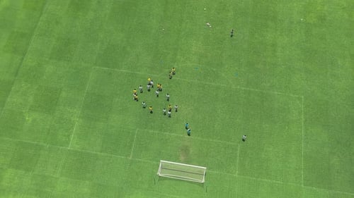 Aerial view of soccer players training on green grass field