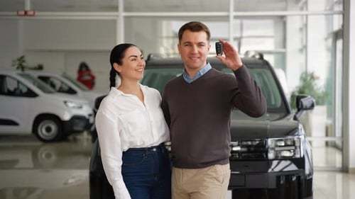Couple Buying New Car in Dealership Holding Car Keys