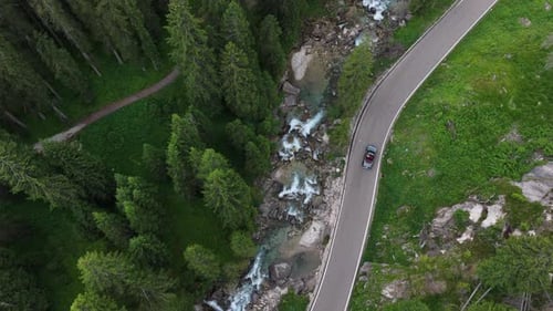 Driving Along a Beautiful Winding Road Next to a Flowing River in the Forest