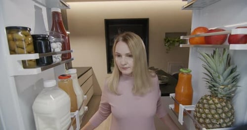 Woman Opens Refrigerator Full of Healthy Food