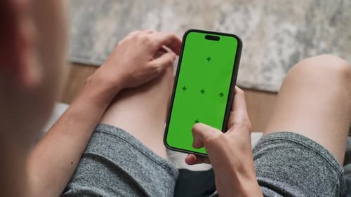 Teenager benutzt Handy mit Greenscreen-Mockup