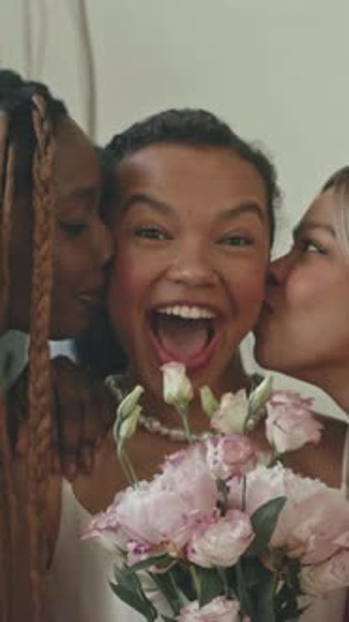 Bridesmaids Kissing Bride on Both Cheeks on Wedding Day