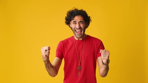 Young Adult Cheering Against Yellow Background