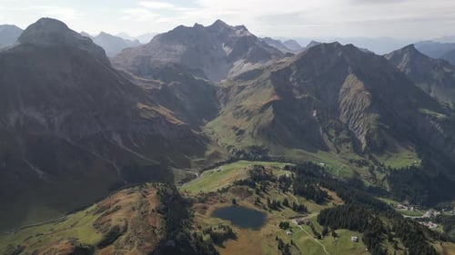 Une vue aérienne époustouflante de Warth, dans le Vorarlberg, en Autriche, avec les majestueuses Alpes en toile de fond, éclairée par le soleil