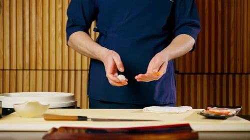 Closeup in Japanese Restaurant the Chef Lays Out Pieces of Raw Fish on a Plate