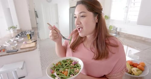 Woman Enjoys Healthy Salad in Bright Kitchen