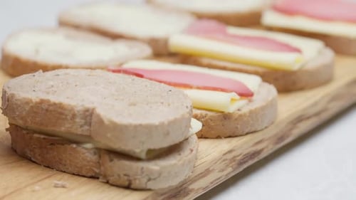 Closing Sandwiches on Wooden Board
