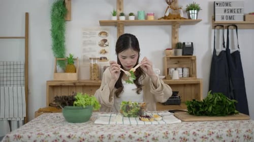 Young Woman Prepares and Stirs Salad in Kitchen