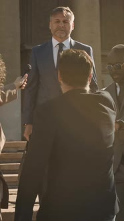 Man Giving Interview to Reporters in Urban Setting