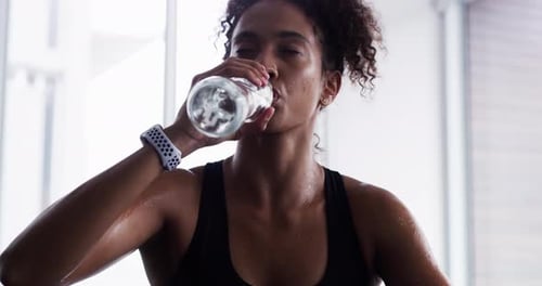 Woman drinking water, fitness and relax after workout, sport and tired with hydration