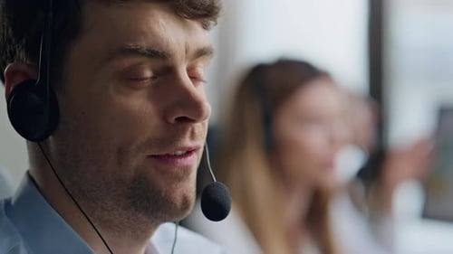 Friendly Agent Speaking Client In Headset Closeup. Positive Man Specialist Work In Call Center Of...