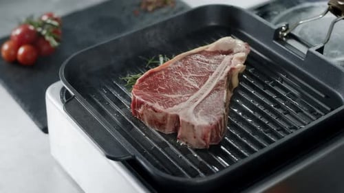 Frisches Steak in der Grillpfanne zubereiten. Nahaufnahme von rohem Rindfleisch beim Grillen
am Cast