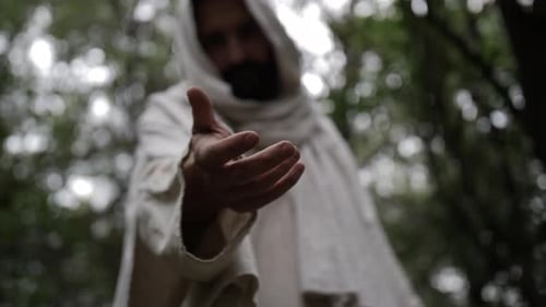 Jesus Cristo, vestindo uma túnica branca esfarrapada, estende a mão para ajudar