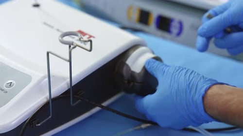 Gloved Hands Working on a Medical Device