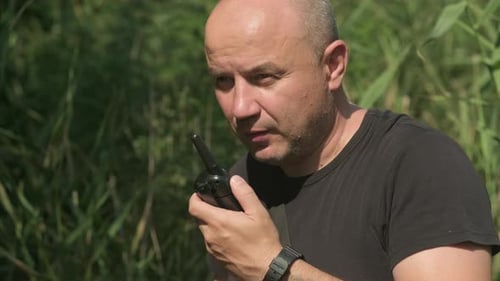 Man Communicating with Walkie Talkie in Natural Setting