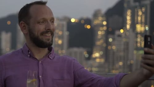 Young Man with Drink Taking Selfie with Cellphone in Bar 30s
