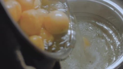 Potatoes Being Poured Into a Steel Pot
