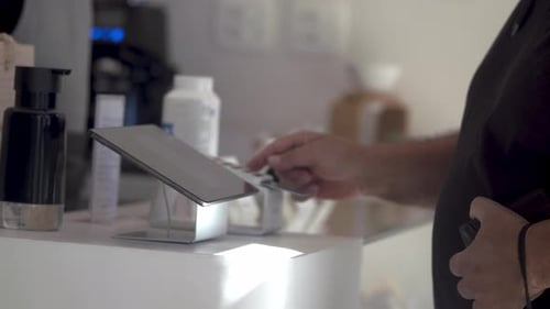 Customer entering information at credit card payment terminal at small business