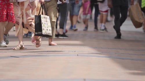 Slow motion of shoppers feet on busy UK high street on summers day