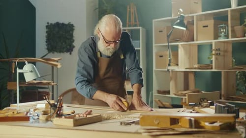 Senior Craftsman Working With Wood In Workshop