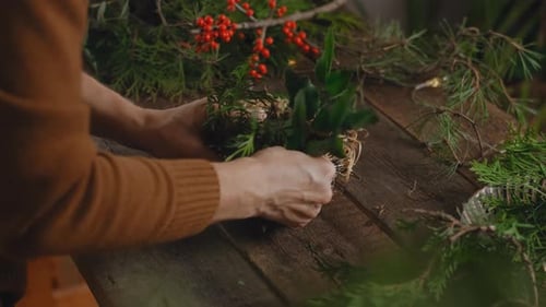 Woman arranging Christmas wreath. Floral workshop, eco friendly craft business