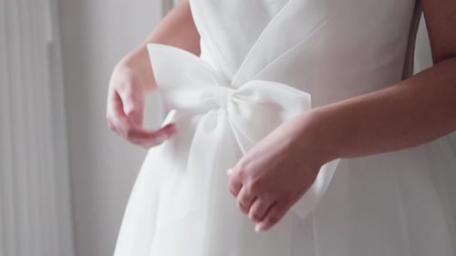 Elegant White Dress Being Adjusted by Young Adult
