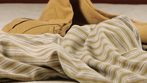 Clothing Items Placed on White Bedspread