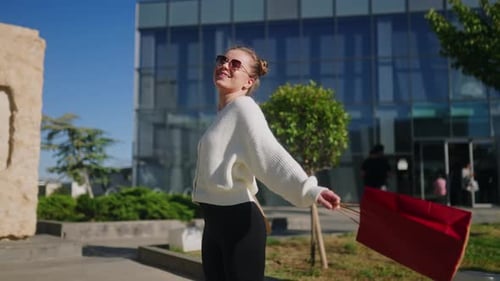 Happy Woman with Shopping Bags Walking in City From Mall Excited Girl Enjoys Purchases on Black