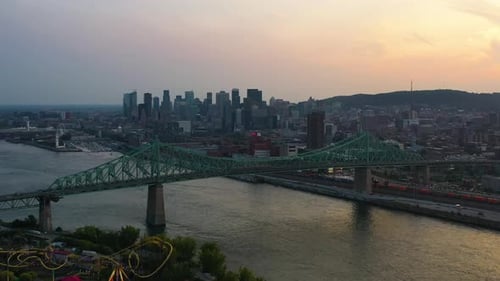 Drone approaching the Jacques Cartier Bridge and skyline of Montreal, sunset in Canada