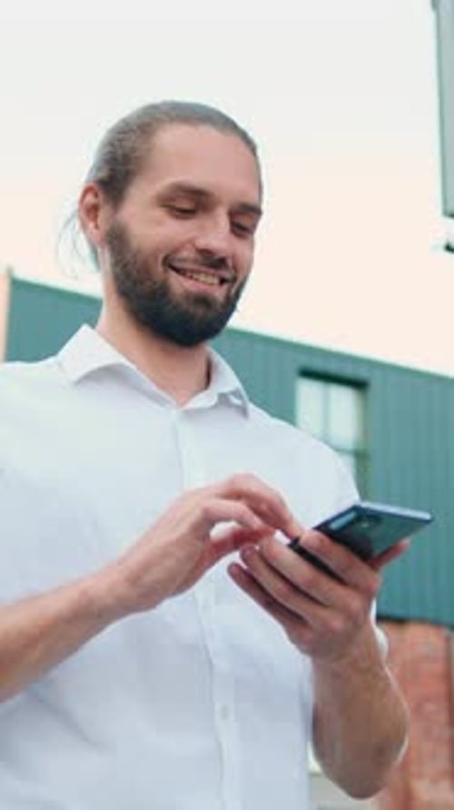 Handsome Bearded Businessman Holding Phone Standing Outdoor By Working Office with Smile Face