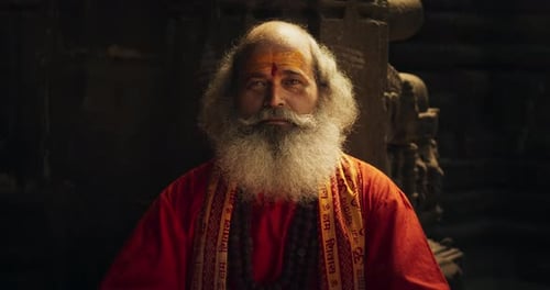 Zoom in Portrait of a Senior Hindu Monk Looking at the Camera and Smiling in an Anci