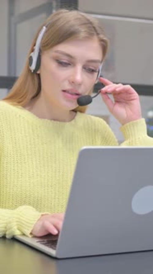 Female Call Center Employee with Headset Talking During Video Chat, vertical video