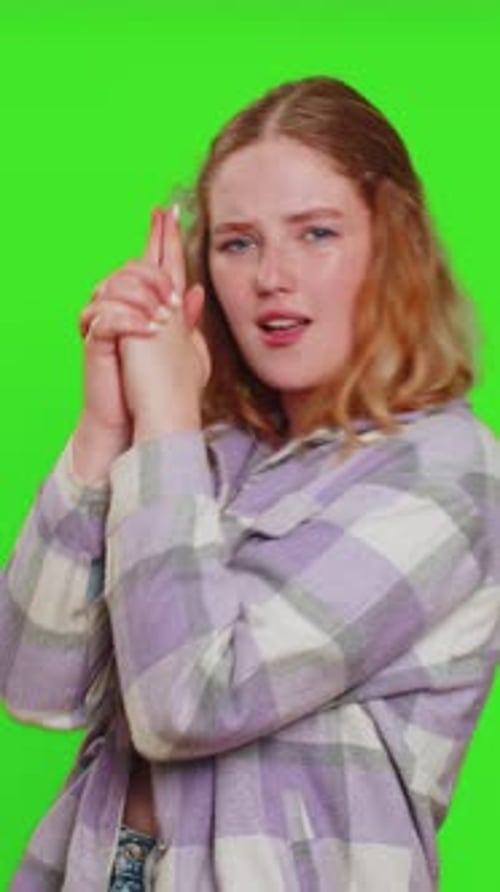 Junge Frau zeigt mit Fingerpistole herum, trifft Wahl, schießt mit Handpistole