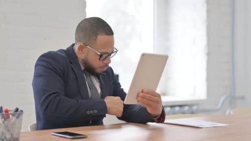 Professional Man Works on Tablet in Bright Office