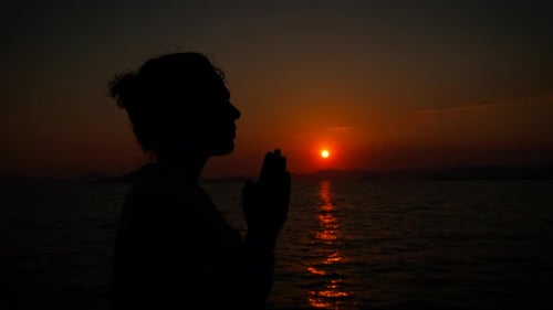 Female Silhouette Pray in the Nightfall