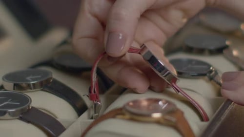 Close Up of Hand Picking Red Wristwatch