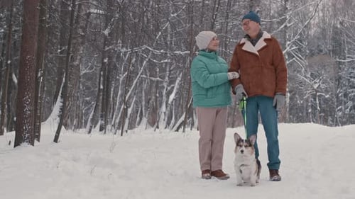 Portrait of Elderly Couple with Dog in Winter Forest