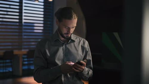Carefree Positive Browsing Phone Mobile App Caucasian Businessman at Evening Office Using Smartphone