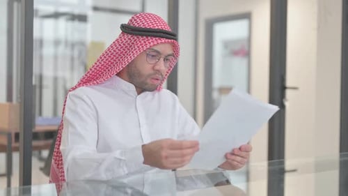 Man Shocked Reading Documents in an Office