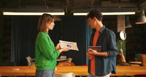 Coworkers Discussing Line Chart Infographic in Creative Office